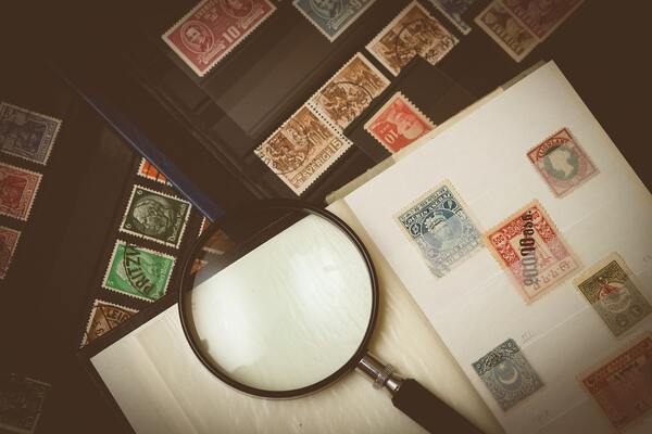 Stamp collection ready to be analysed with magnifying glass and organised into a folder